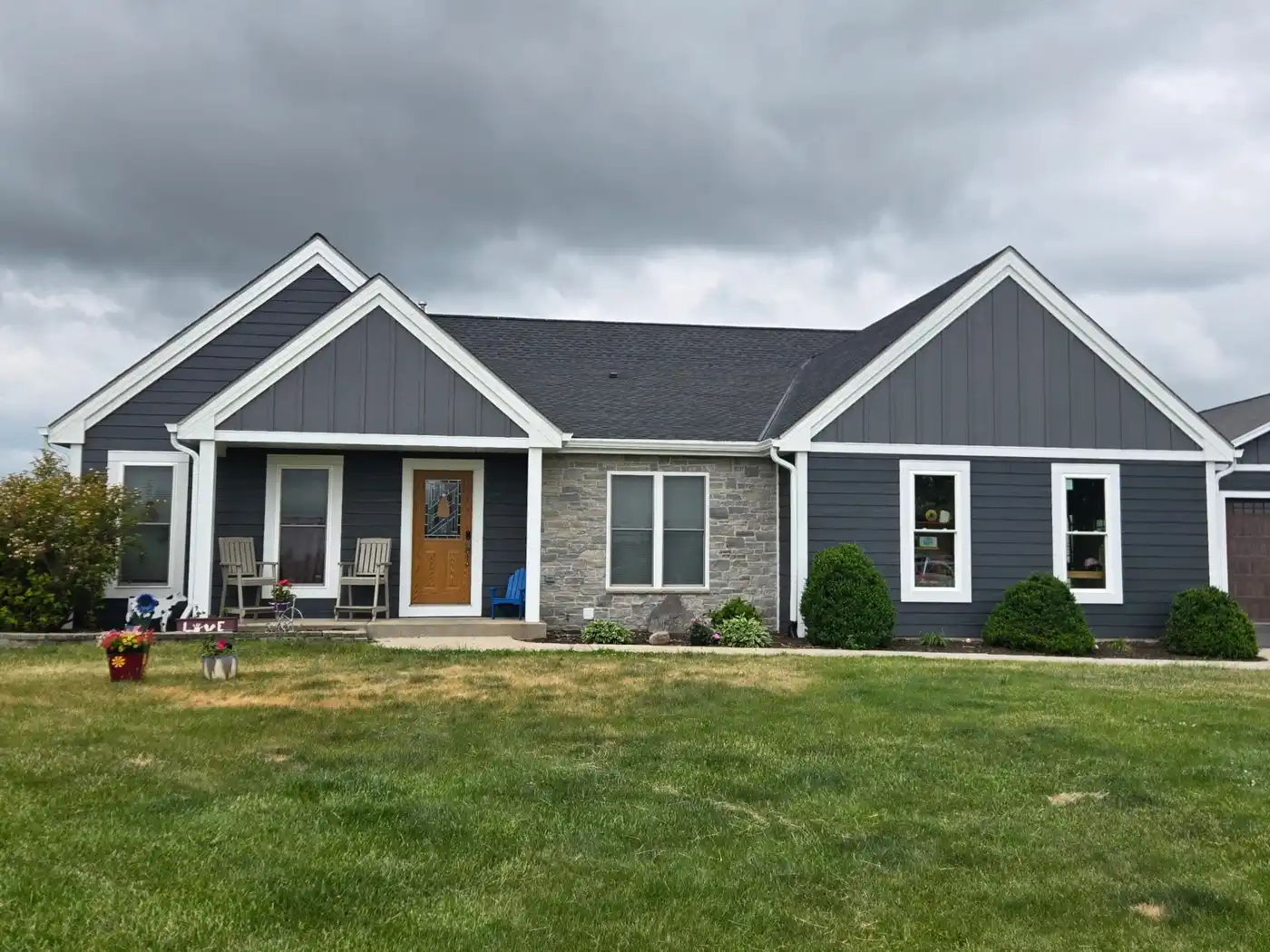 After photo of a Richfield Wisconsin home with dark LP SmartSide siding, new gutters, soffit and fascia
