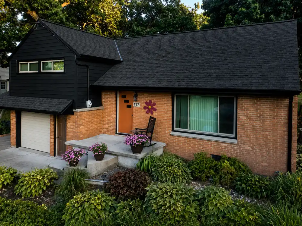 Brownsville WI brick home with black LP SmartSide gable siding and orange front door
