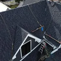 Finished dark architectural shingle roof with valleys and dormer detail on a custom home